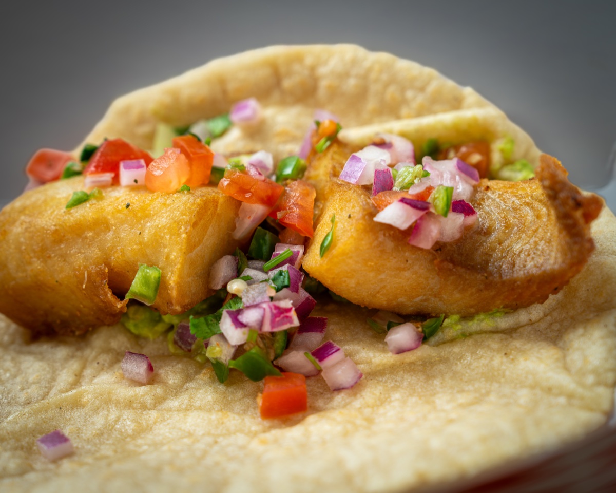 Mariscos El Jaguar fish taco close-up with pico de gallo — editorial food photography