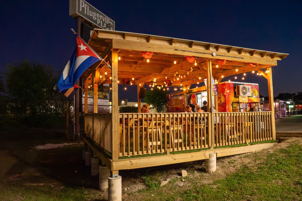512 Pizzeria covered terrace at night, string lights, Cuban flag — Pflugerville Plaza