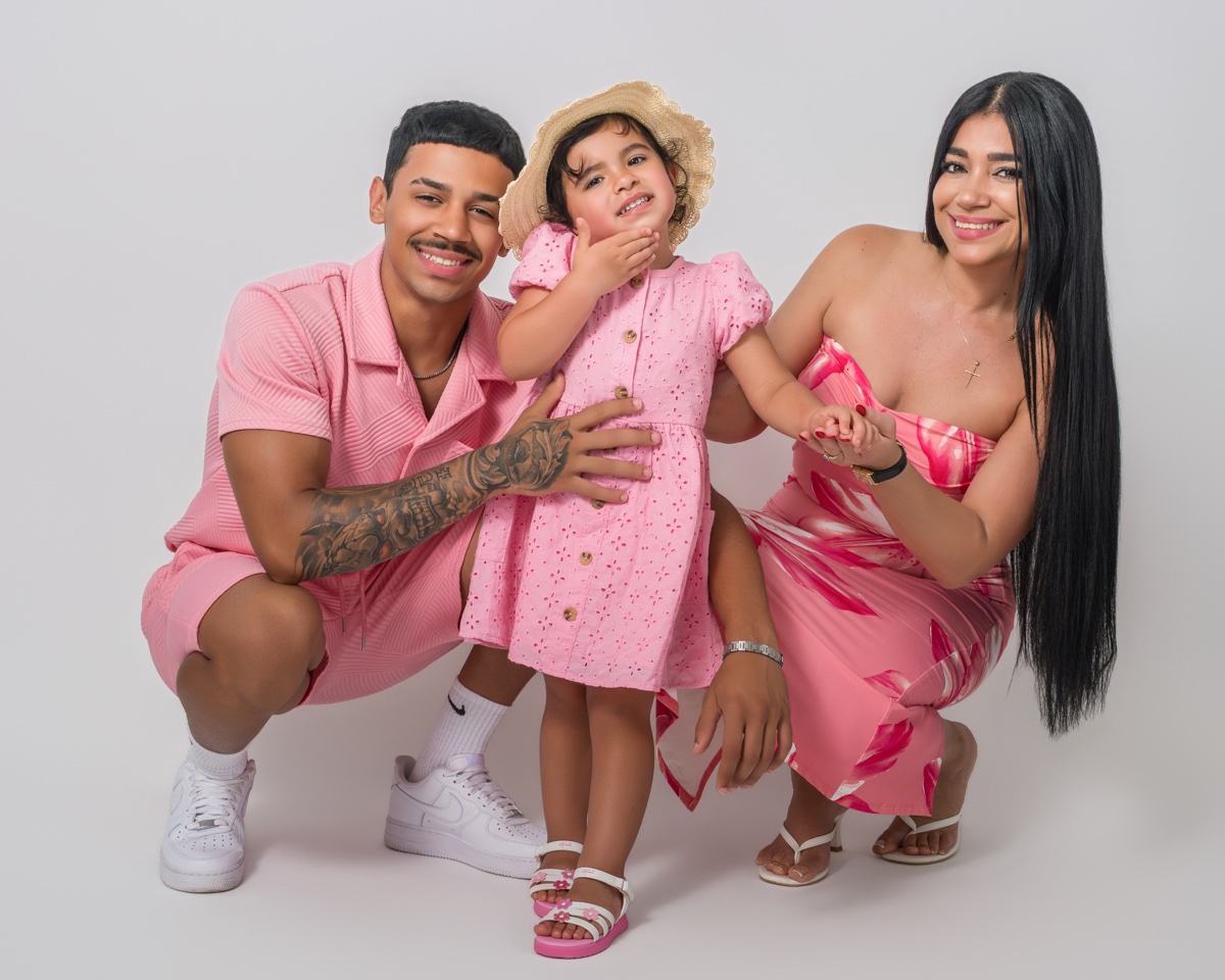 Family studio session in coordinated pink outfits on light backdrop — Austin family photographer